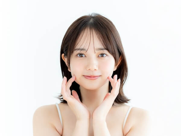肌を指さす笑顔の女性